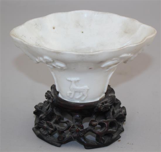 A Chinese Dehua blanc-de-chine libation cup, late 17th / early 18th century, 13cm, carved wood stand